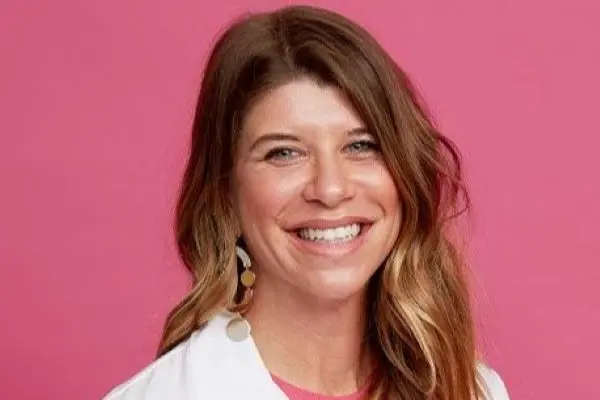 Headshot of Carla Fisher against a pink background.