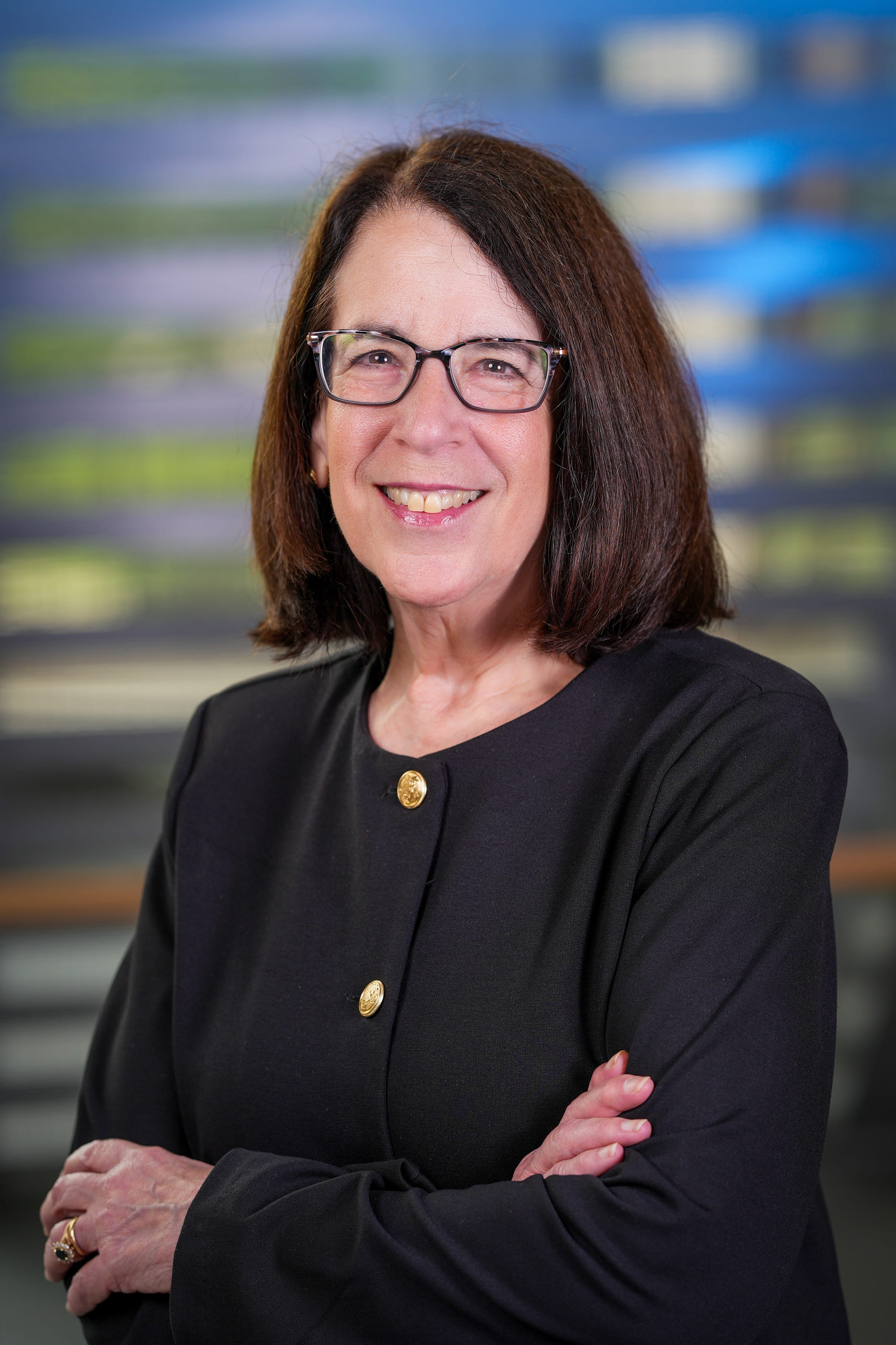 Portrait of Dr. Clair Francomano, smiling with arms crossed