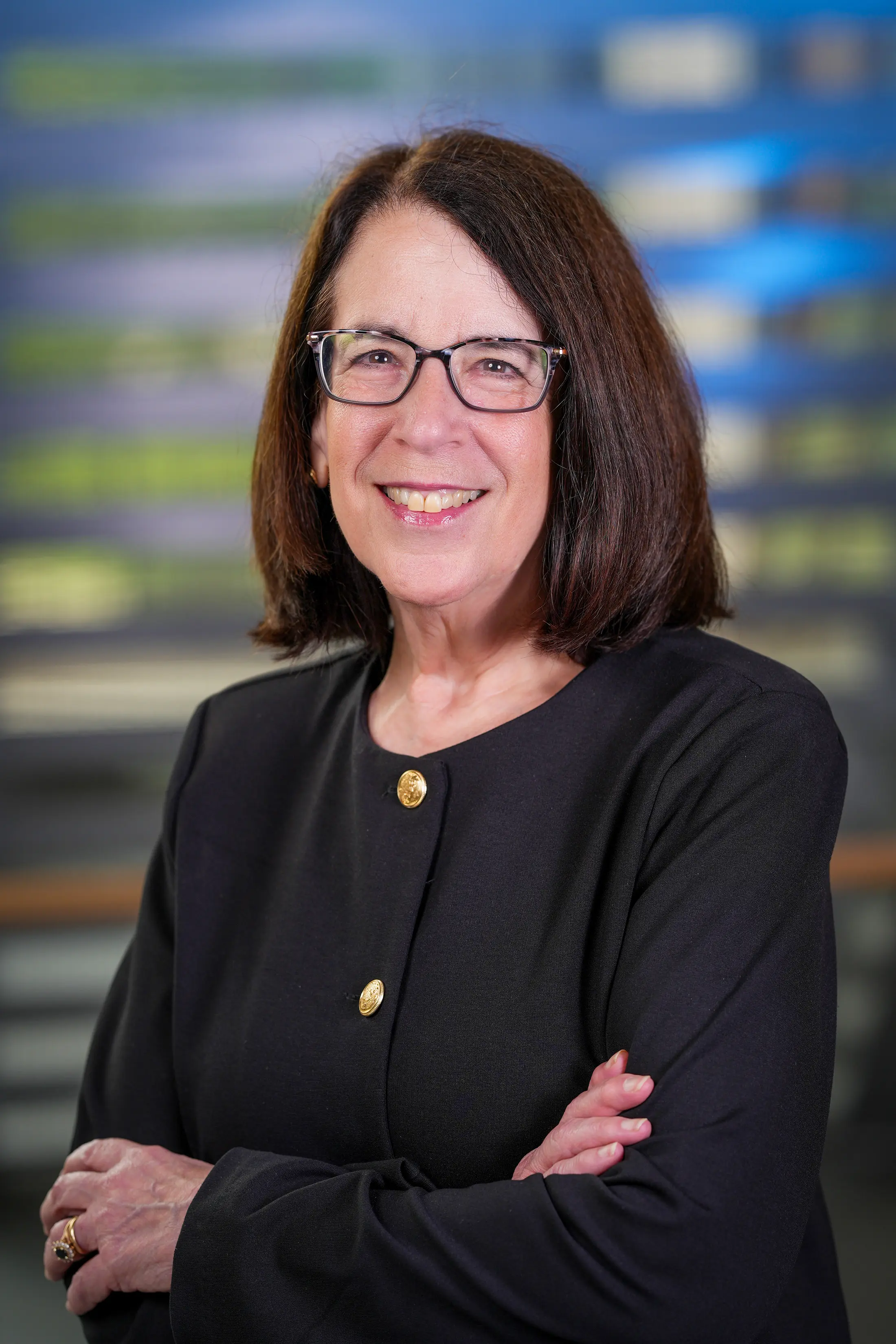 Portrait of Dr. Clair Francomano, smiling with arms crossed