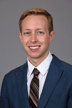 Headshot of Colin Halverson, a Caucasian man wearing suit and tie