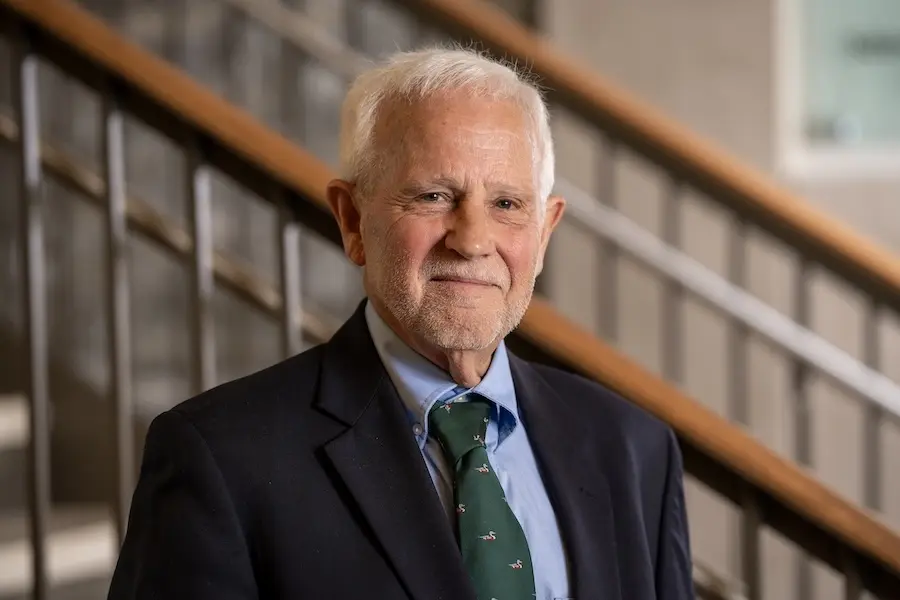 Portrait of Dr Patrick O'Neil wearing blue suit and green tie in front of a staircase at IU School of Medicine--West Lafayette