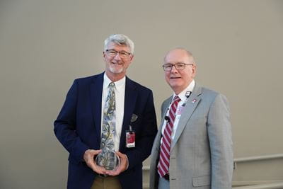 James Williams holds his award and stands with Dean Jay Hess