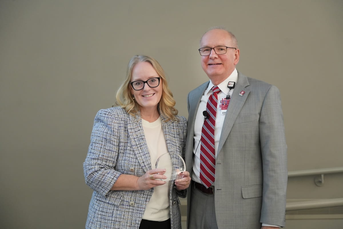 Melissa Kacena holds her award and stands with Dean Jay Hess