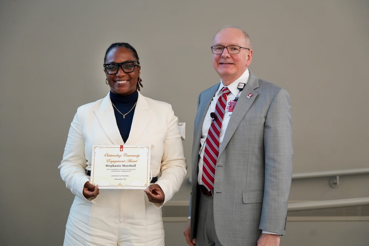 Stephanie Marshall holds her award and stands with Dean Hess