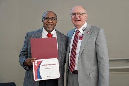 Keith Ramsey displays his award certificate and stands with Dean Jay Hess