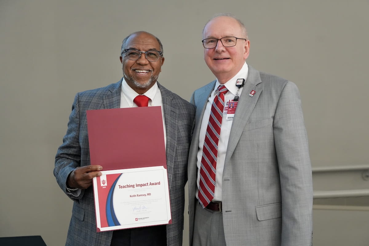Keith Ramsey displays his award certificate and stands with Dean Jay Hess