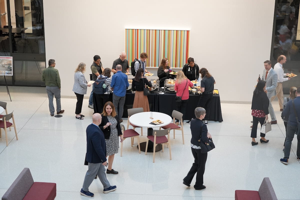 People mingle in the lobby of the Medical Education and Research Building after the All School Meeting.