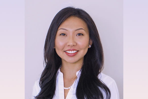 Headshot of Gloria Xue wearing white blouse on light background