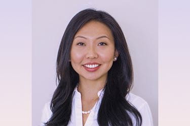 Headshot of Gloria Xue wearing white blouse on light background
