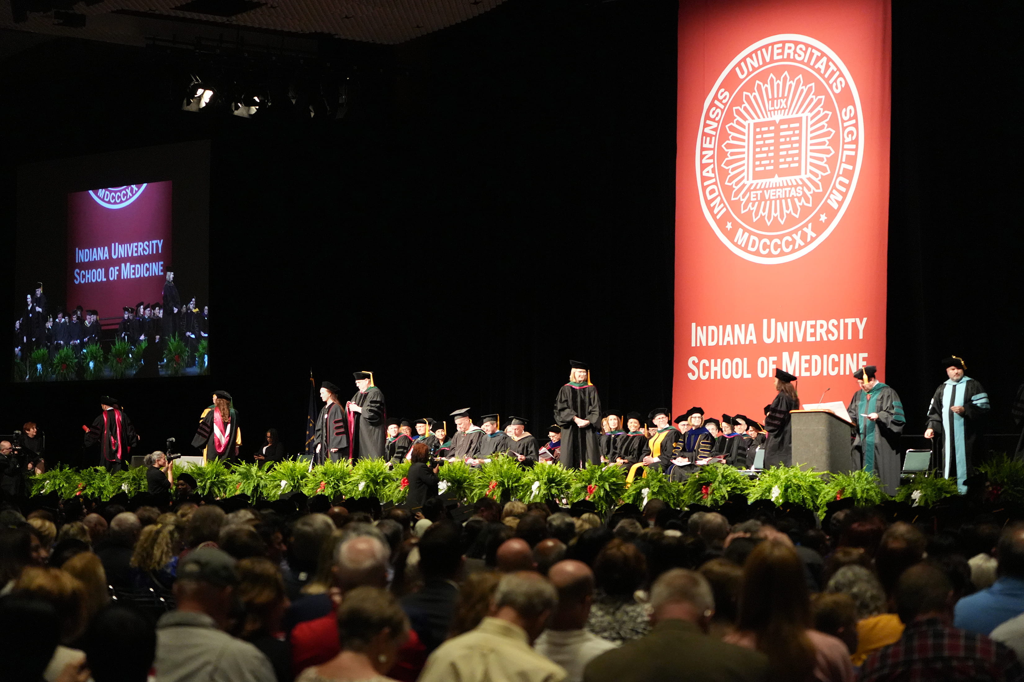 Graduates walking across the stage at the IU School of Medicine 2023 commencement ceremony.