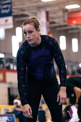 Erin Conboy, in BJJ attire, stands on the grappling mat with a black eye