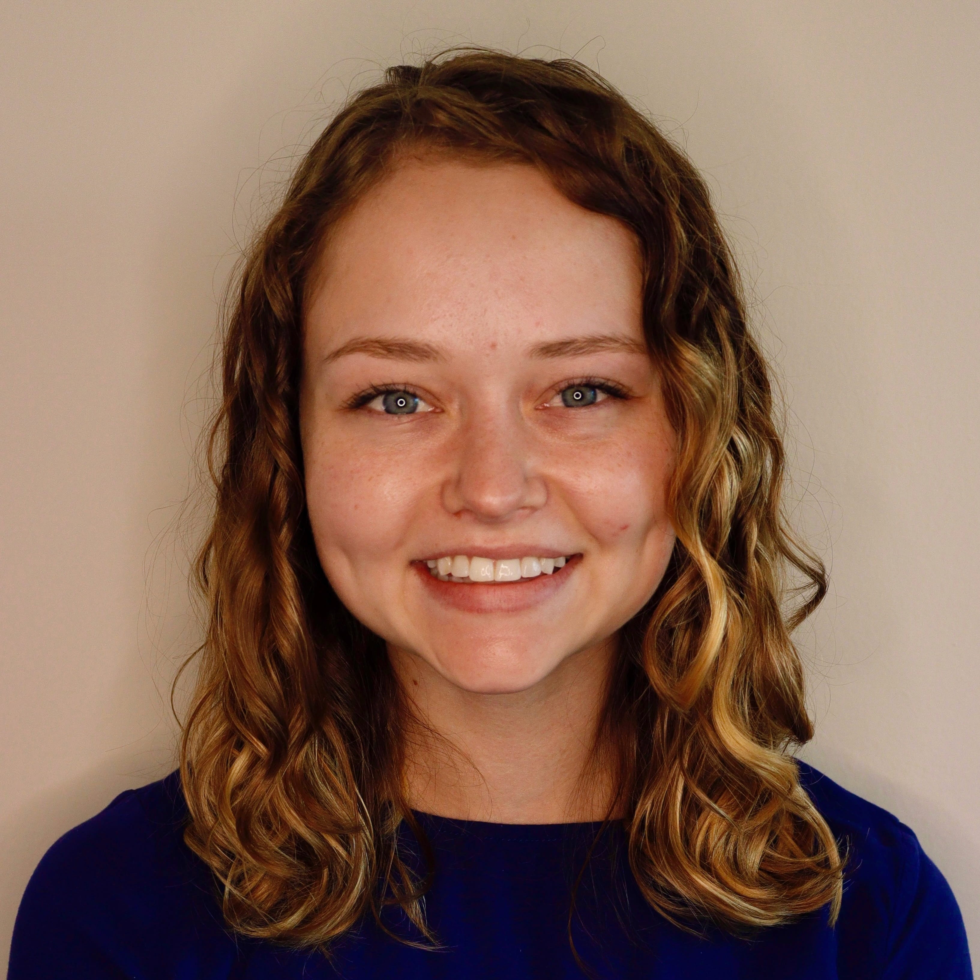 Headshot of Lindsey Smith, white woman with wavy hair in navy Tshirt