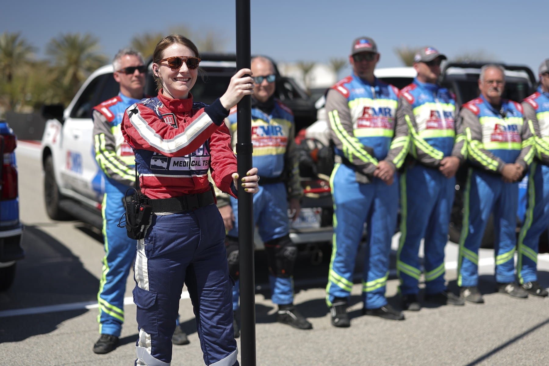Liz Sullivan in Medical Team fire suit, holding flag at the Indianapolis Motor Speedway