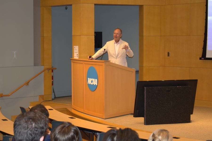 Orthopaedic Surgeon, Mark Mighell, MD, from the Florida Orthopaedic Institute, presents the 2025 Garceau-Wray Lecture at the podium of an NCAA Hall of Champions auditorium.