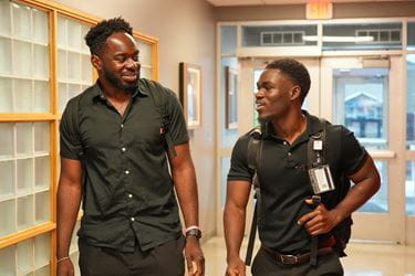 Abdulmalik Kareem and Mout-Maine Moustapha walk into the Van Nuys Medical Science Building together. | Photo by Tim Yates, IU School of Medicine Abdulmalik Kareem and Mout-Maine Moustapha walk into the Van Nuys Medical Science Building together, both dressed in black shirts and black pants and carrying backpacks.