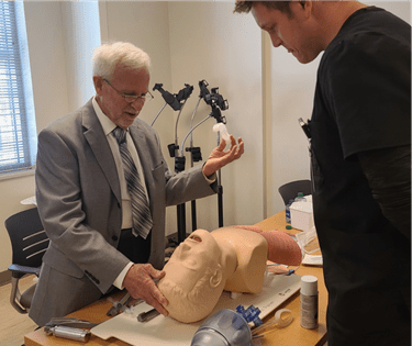 Dr. Patrick O'Neil works with a manikin while instructing a medical student.