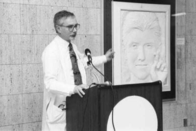 Dr. Kleiman pointing to the Ryan White Sculpture at a dedication event in 1992
