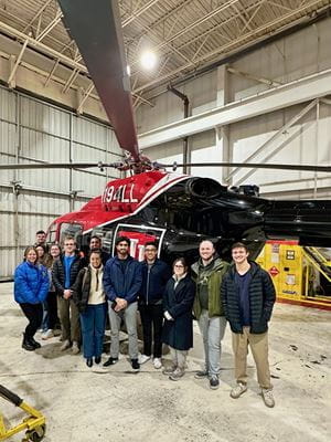 Students from the Aerospace Medicine SIG stand in front of the IU Health LifeLine helicopter.