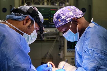 Surgeons Avinash Mantravadi and Kenny Sargo perform head and neck surgery in Kenya | Photo by Jonathan Ting, MD, IU School of Medicine Surgeons in scrubs