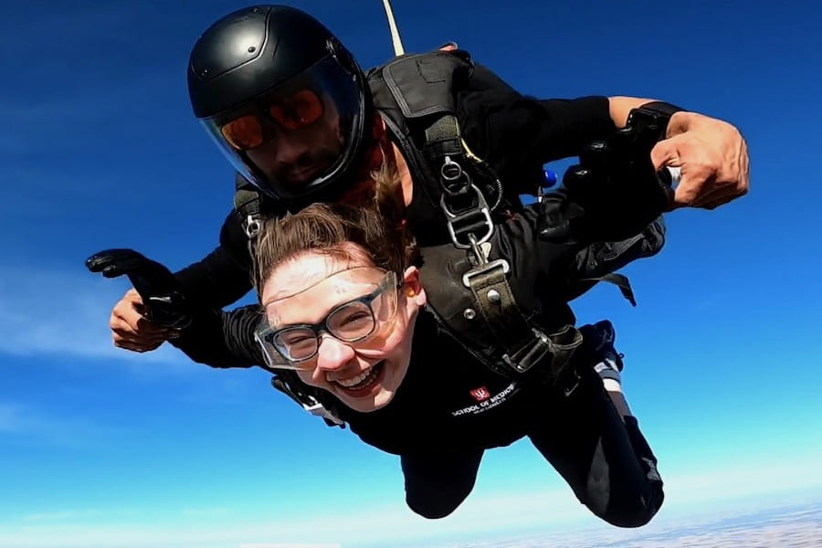 Sarah Vaught in air, during a tandem skydive, with a big smile on her face