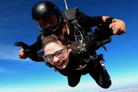 Sarah Vaught in air, during a tandem skydive, with a big smile on her face