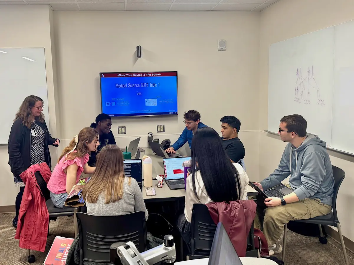 A group of medical students and a faculty member engage in a small group session