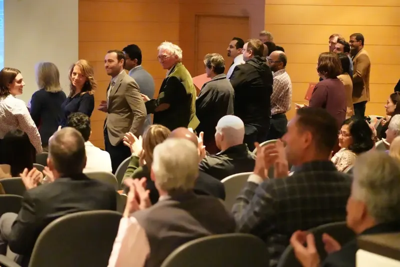 Trustees Teaching Award winners stand and receive applause at the Spring 2025 All School Meeting.