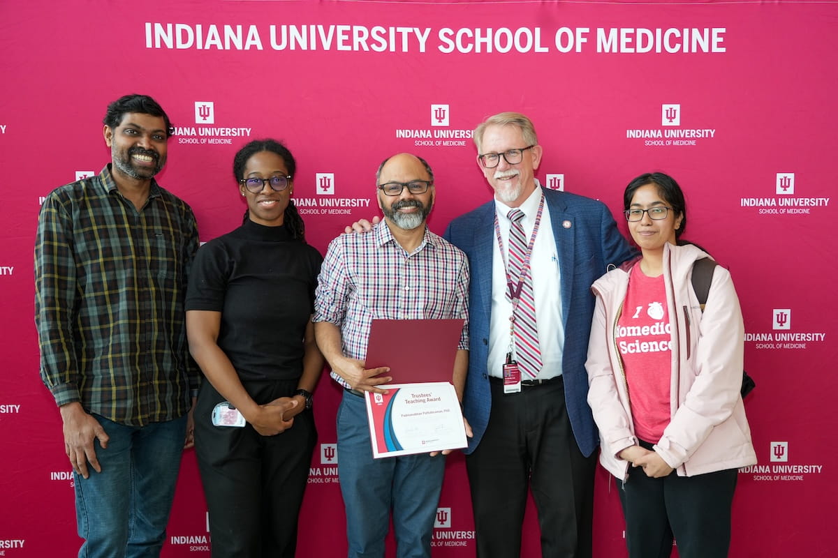 Padmanabhan Pattabiraman stands with his family and award in hand for a photo with Bradley Allen of Educational Affairs.