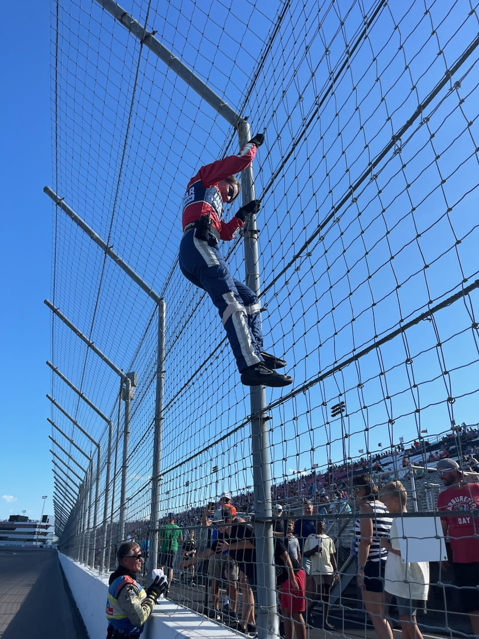 Liz Sullivan climbs the fence at the Indianapolis Motor Speedway to remove a T-shirt
