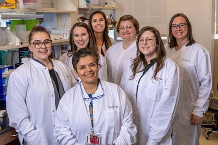 Malu Tansey is surrounded by the all-female members of her laboratory at IU School of Medicine.
