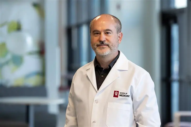 A man (Tim Richardson) with close cropped gray hair and an IU School of Medicine lab coat in the laboratory setting.