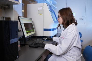 researcher sitting at computer in lab