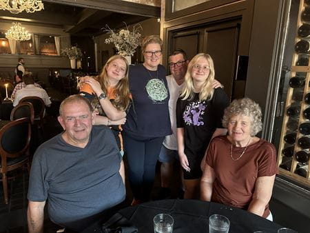 Wilcock family photo inside a restaurant with Donna in the middle, pictured with her husband, daughters and parents