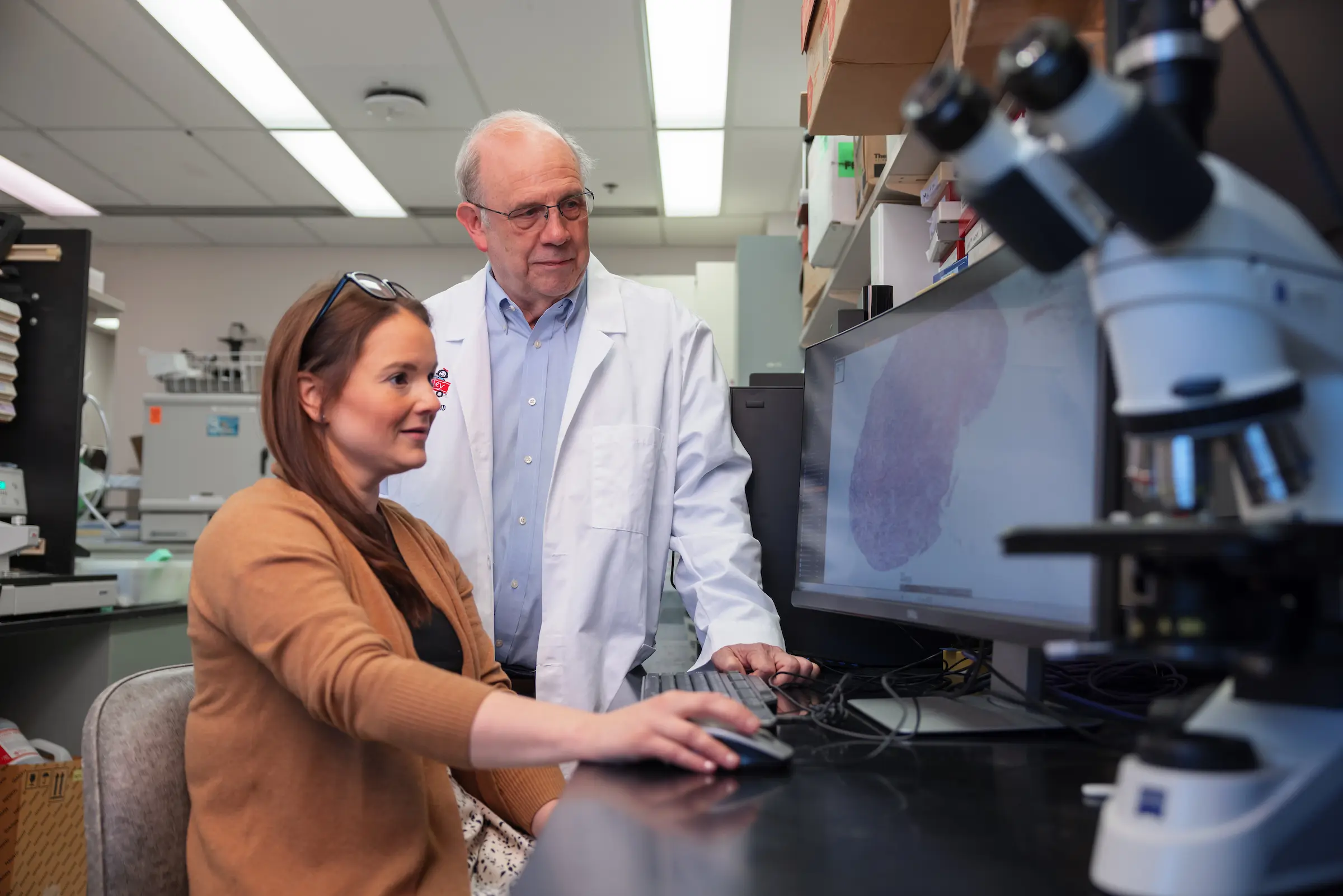 Wade Clapp works with Dana Mitchell in the lab examining an image on a computer screen