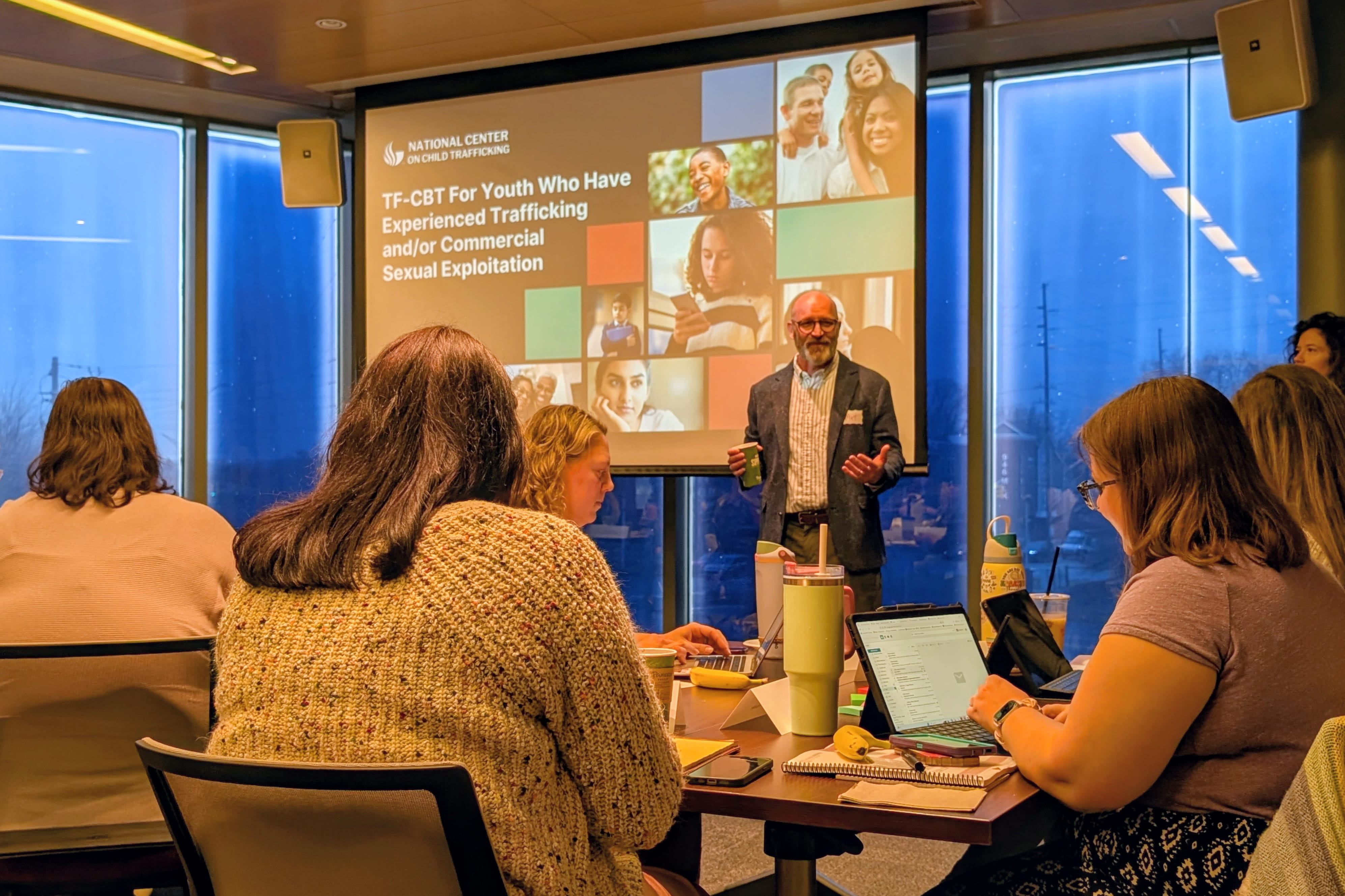 A man speaks to a group of trainees. 