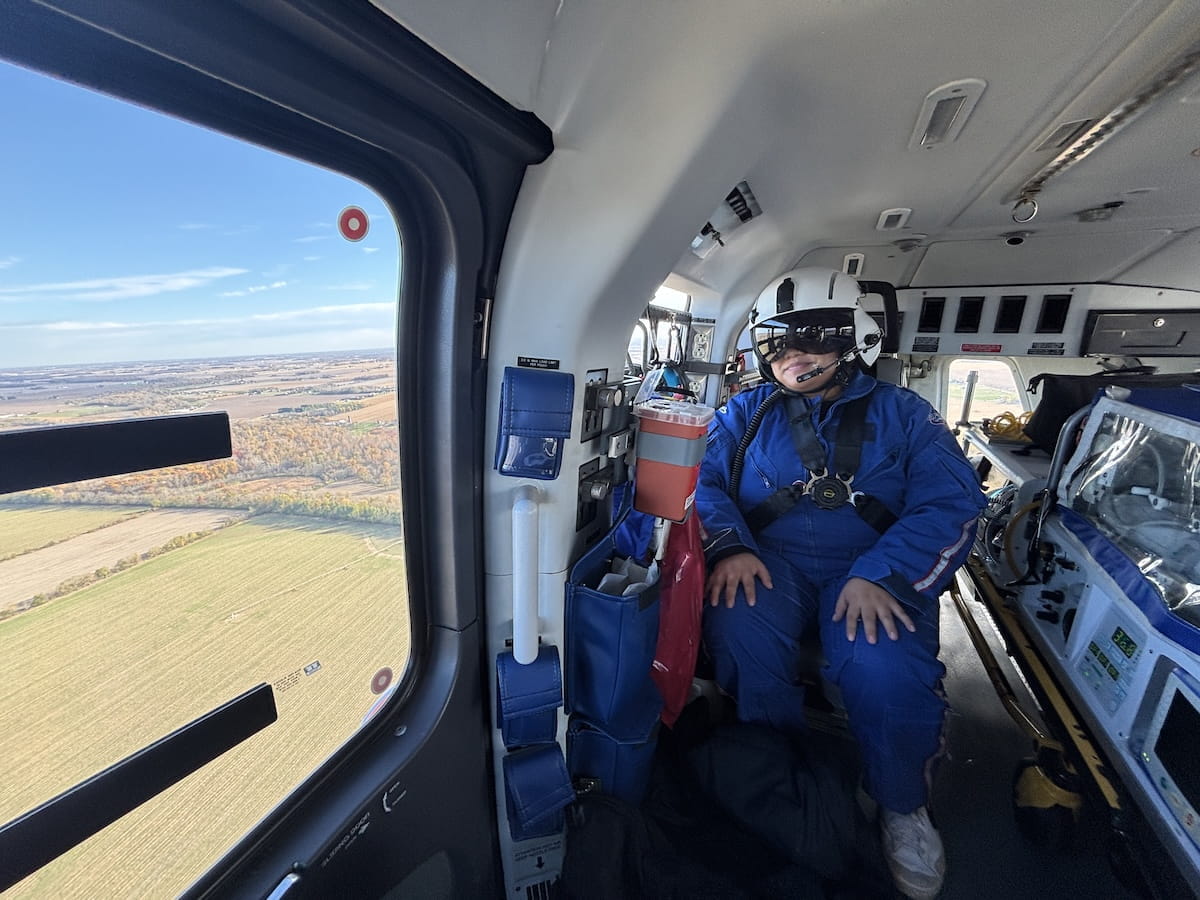 Desiree Cariaso sits inside the LifeLine helicopter wearing a flight suit, helmet and goggles