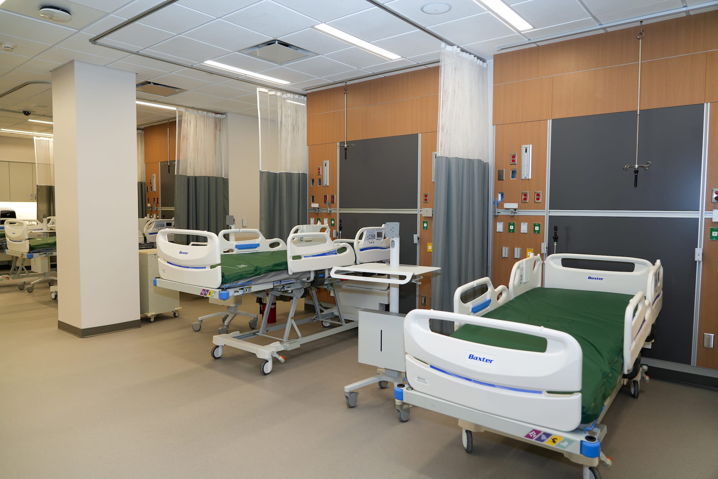 A series of hospital beds separated by curtains in the simulation center