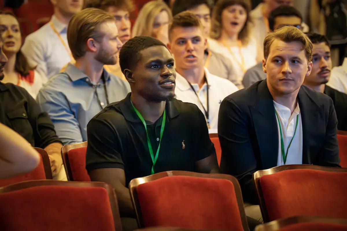 Maine Moustapha sits in a theatre with a lanyard around his neck among incoming medical students during orientation week.