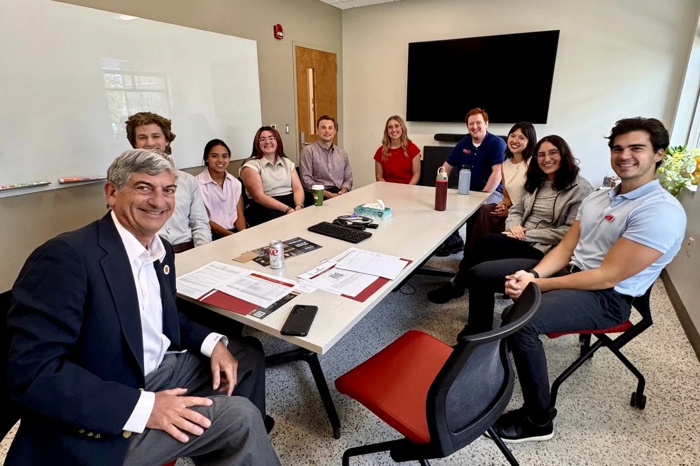 Dean Scott Boden sits around a conference room table with IU medical students at a regional campus.