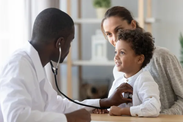 A doctor checking a child's lungs with a stethoscope
