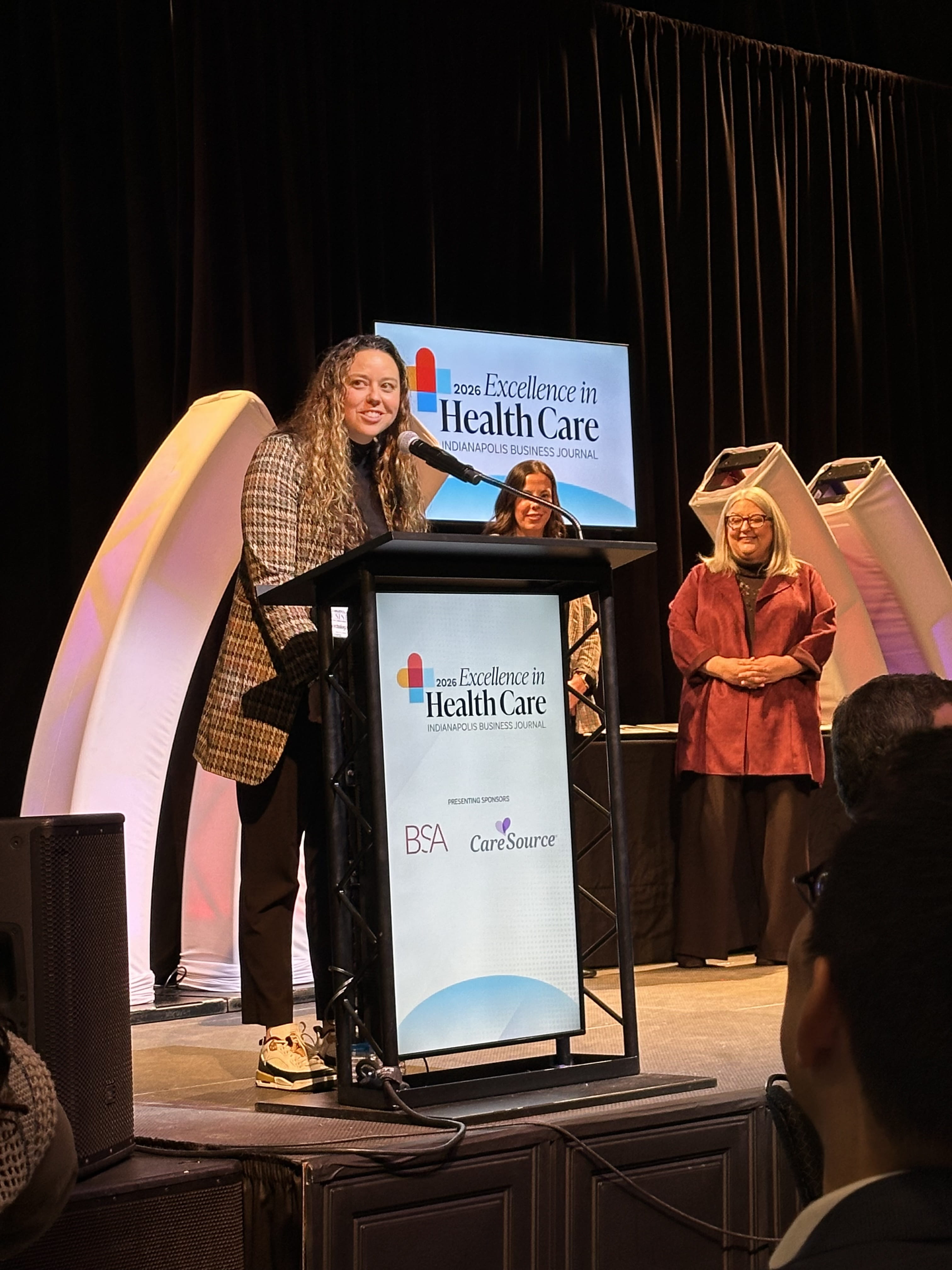 Elaine Gilbert speaks at a podium as she receives an award