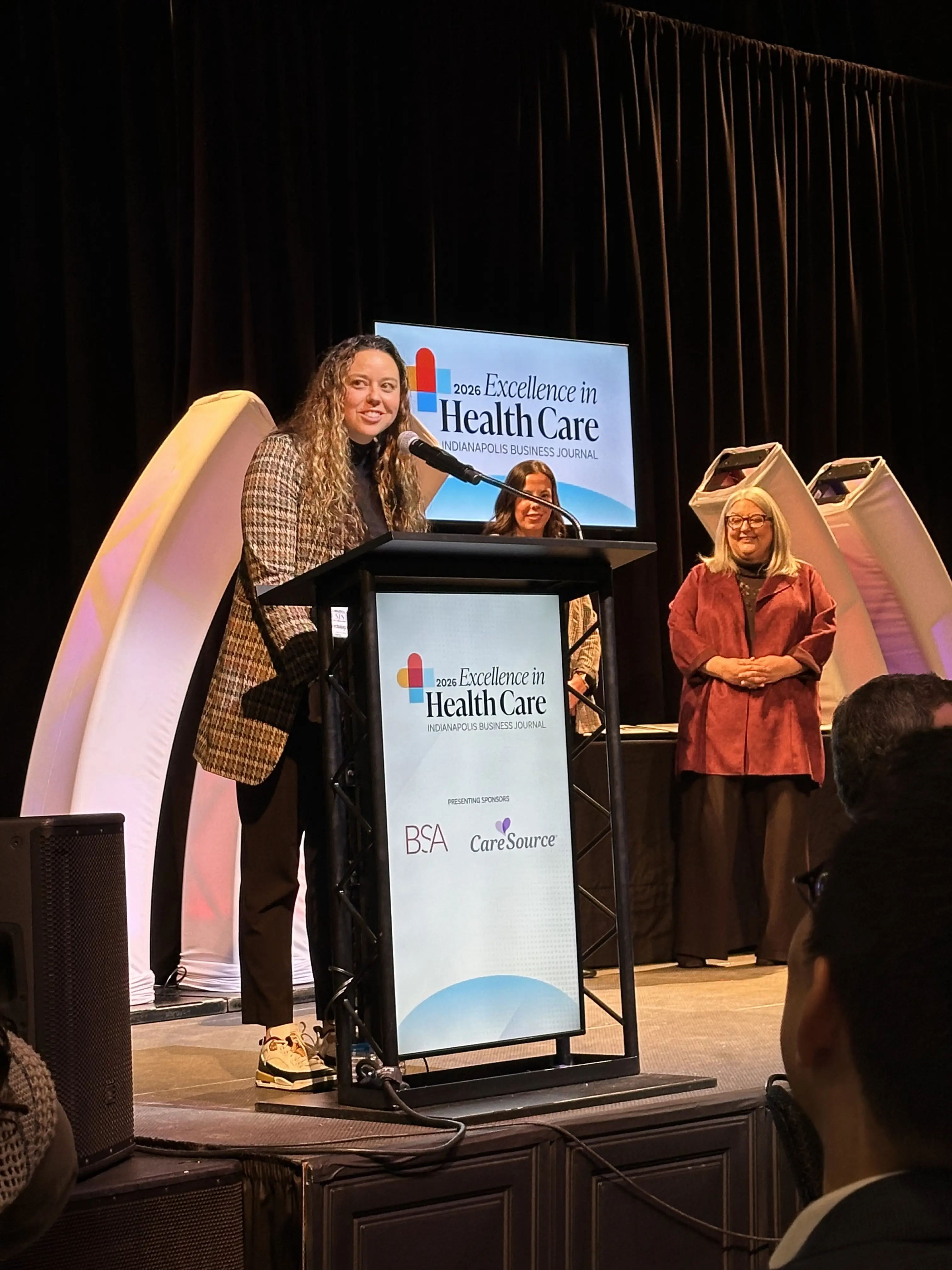 Elaine Gilbert speaks at a podium as she receives an award
