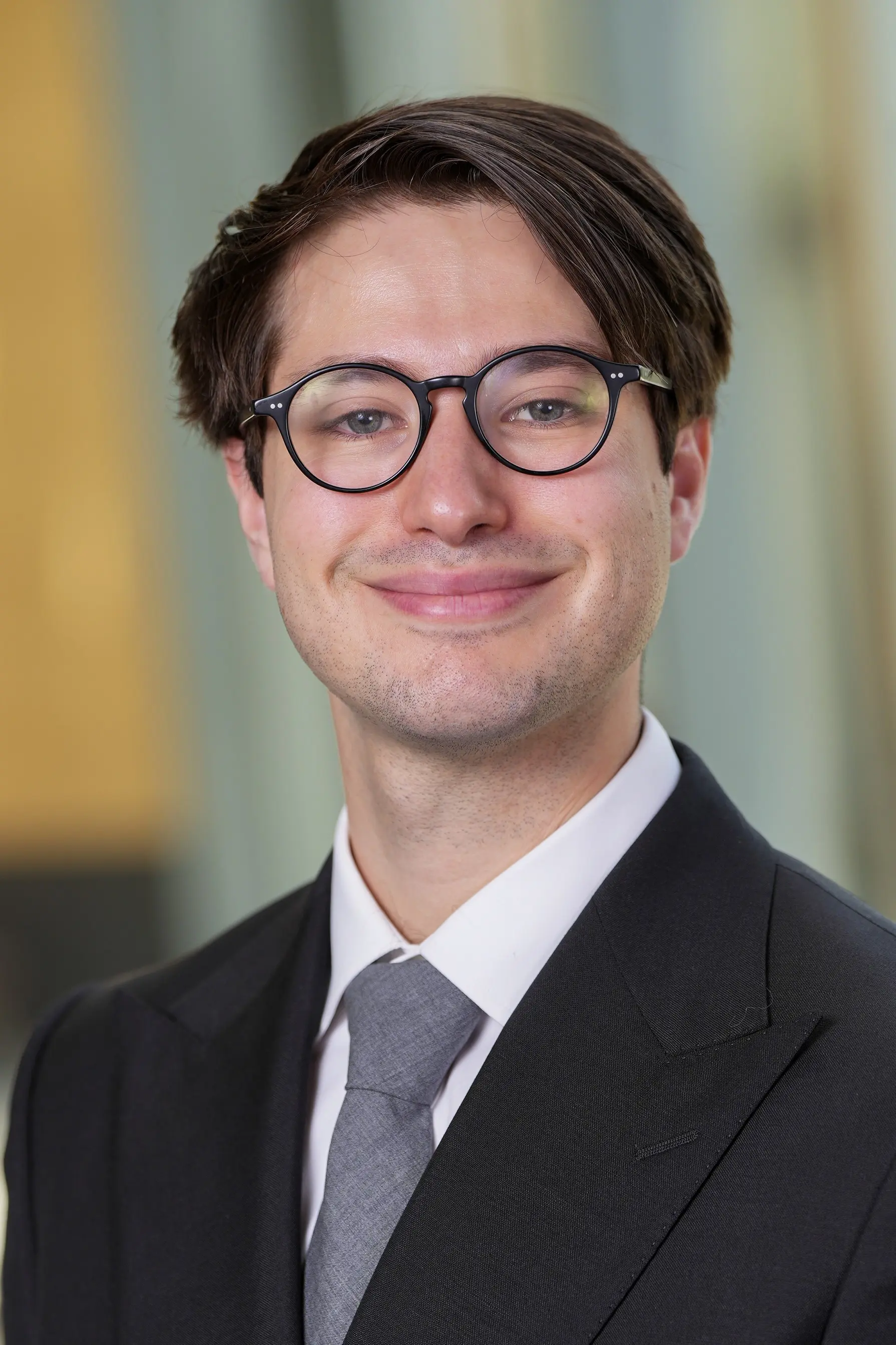 Person in professinal attire in front of blurred office lobby background