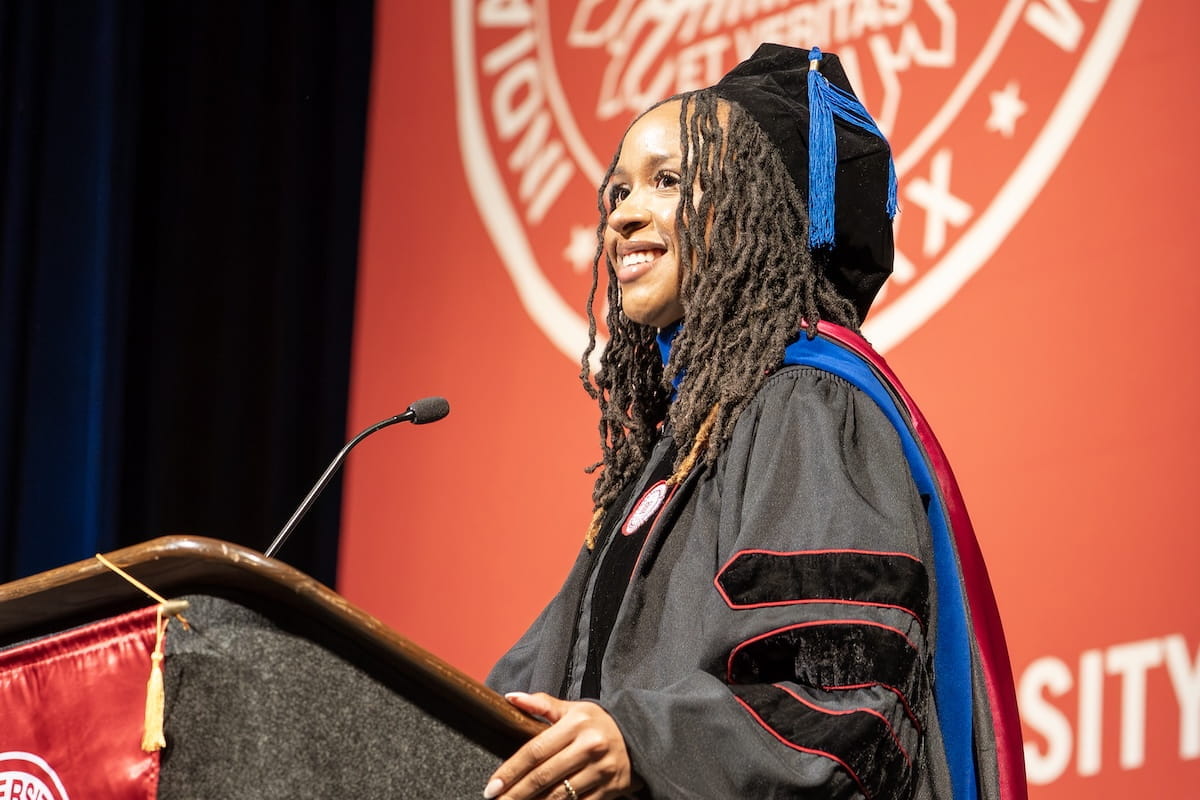Ivana Daniels in cap and gown speaking at podium