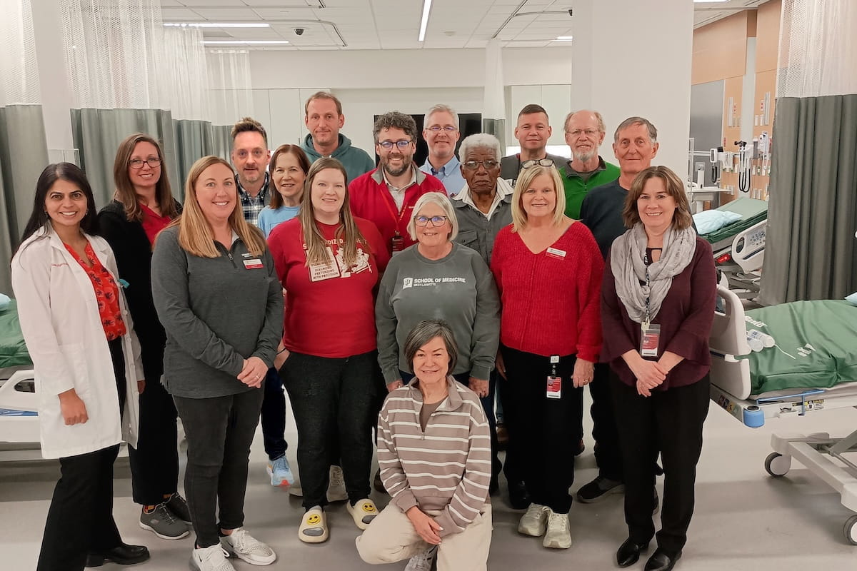 A large group of IU faculty and staff pose in the MERB simulation center