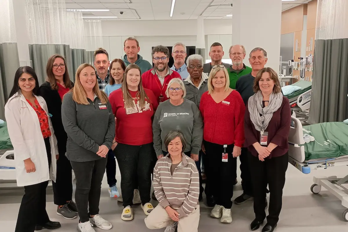 A large group of IU faculty and staff pose in the MERB simulation center