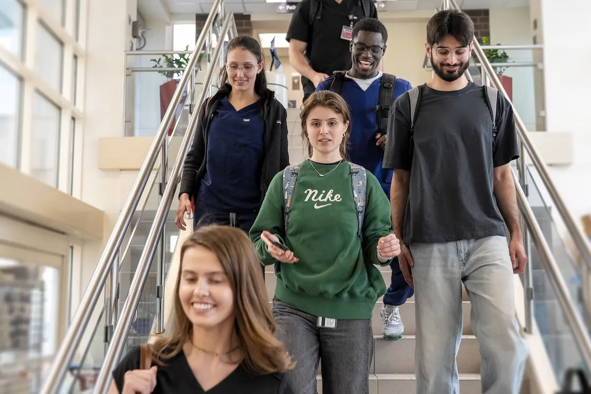 A group of IU medical students walks together down a stairway.