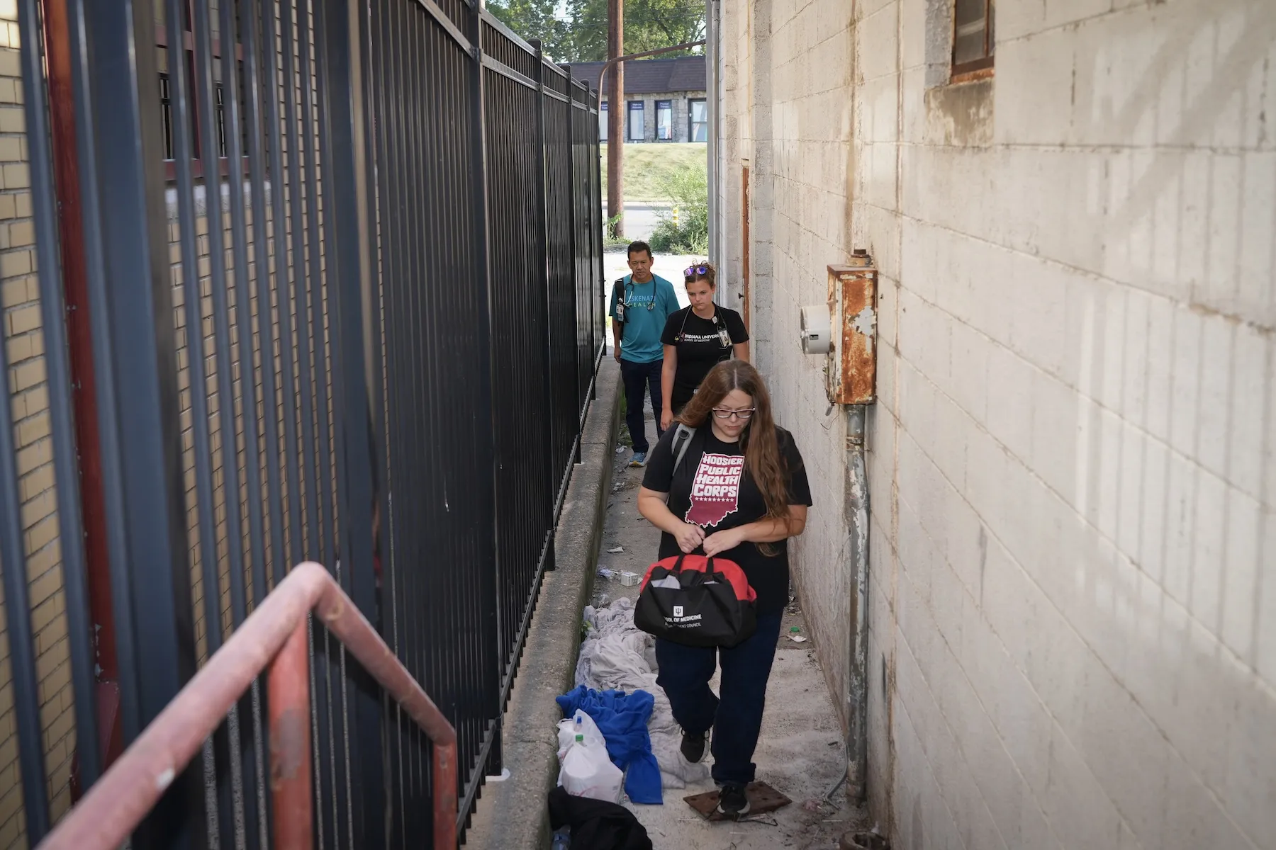 Niki Messmore, Mary Slaughter and Ira Means walk through an alleyway.