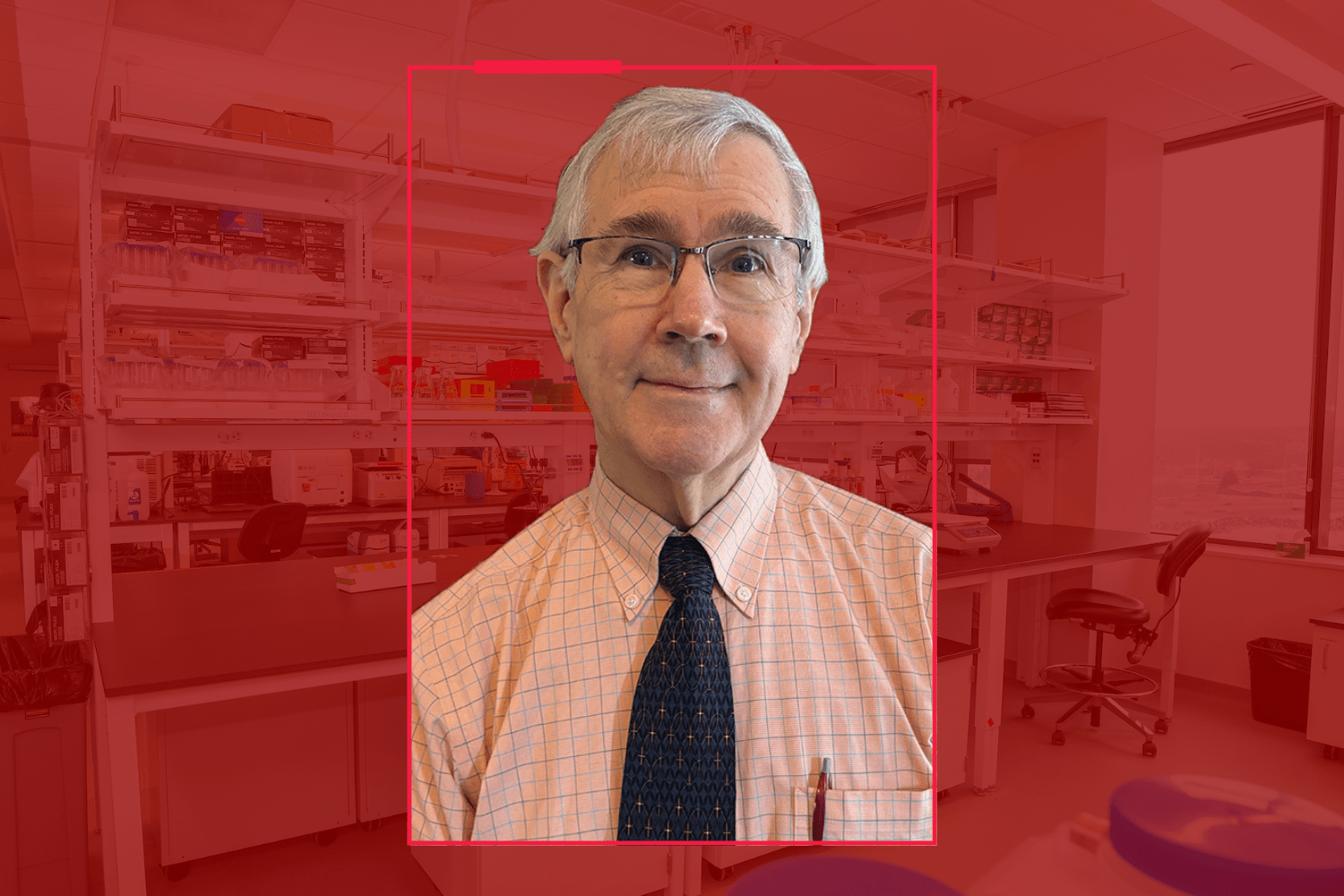 A man in a tie set in a red background. 