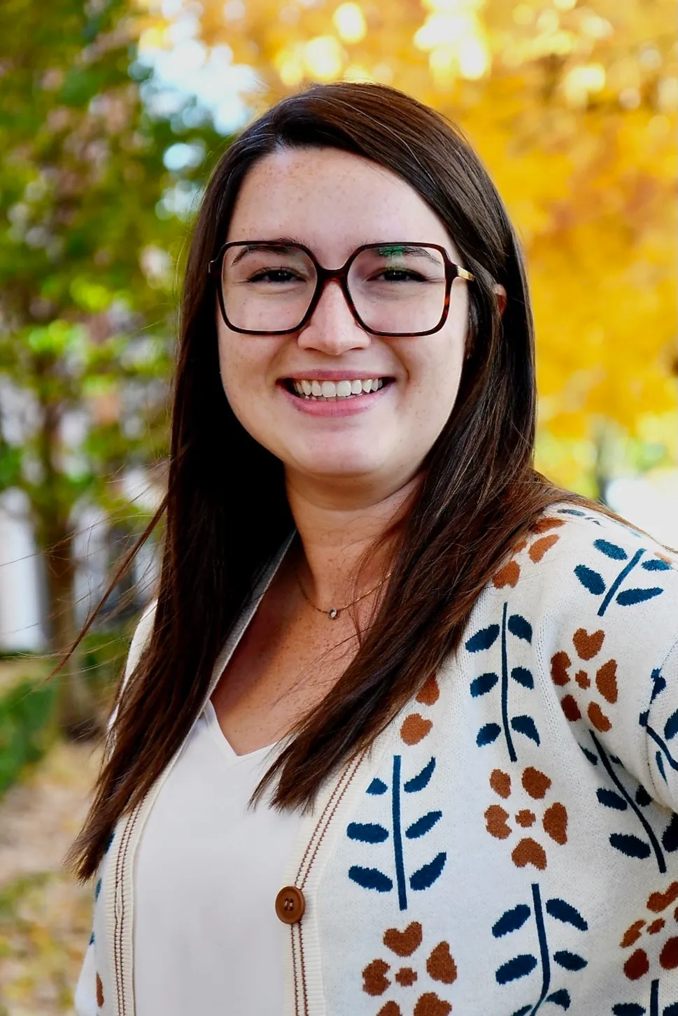 Agnes Zybura Wardrop headshot with colorful fall outdoor background.